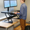 Person using a laptop at the Ergotron WorkFit-TL sit-stand workstation.