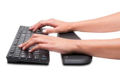 The Kensington ErgoSoft™ Wrist Rest for Slim Keyboards placed beside a slim keyboard on a desk.